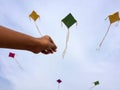 Hand of a boy raises a kite in a sky