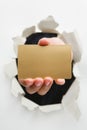 Hand breakthrough wall holding empty golden card Royalty Free Stock Photo