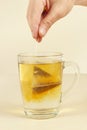 Hand brews tea bag in cup of boiling water Royalty Free Stock Photo