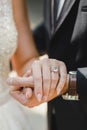 The hand of the bride in the hand of the groom. Wedding ring with a large gemstone on the finger.