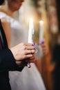 The hand of the bridegroom holding a burning candle at the wedding ceremony Royalty Free Stock Photo