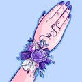 The hand of a bridesmand having a blue and violet floral corsage on her wrist. Wedding conceptual art with flowers, ribbons, leave