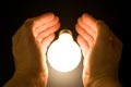 Hand and a Bright Light Bulb Royalty Free Stock Photo