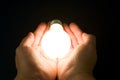 Hand and a Bright Light Bulb Royalty Free Stock Photo