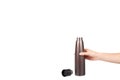 Hand with brown metal thermos, travel mug for hot drinks