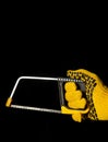 Hand builder holding a hacksaw with clipping path on black isolated background