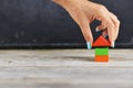 Hand building small wooden house from colourful small pieces