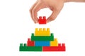 Hand building up a wall by stacking up lego, business conception