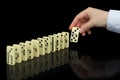Hand builds a line of dominoes on black background Royalty Free Stock Photo