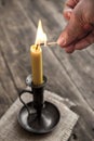 Hand burning candle on wooden background