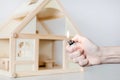 Hand with burning lighter against wooden house model on the background. Arson of house concept. Criminal accident Royalty Free Stock Photo