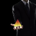 Hand of Business Man Hold triangle on dark background. Royalty Free Stock Photo