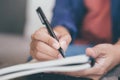 Hand business woman are sitting using pen writing Record Lecture note pad into the book in coffee shop Royalty Free Stock Photo