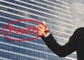 hand of business woman using yellow pen write profit text on Glass wall of tall building of background. Royalty Free Stock Photo