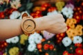 hand business woman wearing wooden watch with copy space and beautiful flowers background. image for