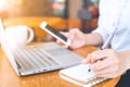 The hand of a business woman writing with a pen in notepad and w Royalty Free Stock Photo