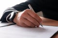 Hand of a businessman with elegant watch on his wrist signing a document Royalty Free Stock Photo