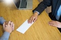 Hand of a businessman hands over a resignation letter final remuneration to executive boss on a wooden table to his boss Change of Royalty Free Stock Photo