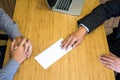 Hand of a businessman hands over a resignation letter final remuneration to executive boss on a wooden table to his boss Change of Royalty Free Stock Photo