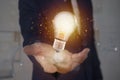 Hand of businessman holding illuminated light bulb, idea, innovation Royalty Free Stock Photo