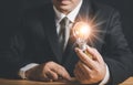 Hand of businessman holding illuminated light bulb, idea, innovation and inspiration concept Royalty Free Stock Photo