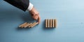 Hand of a businessman interrupting collapsing dominos with his finger Royalty Free Stock Photo