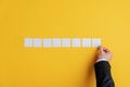 Hand of a businessman placing eight blank white post it papers in a row Royalty Free Stock Photo