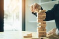 Hand of businessman playing wood blocks stacks game with planning strategy of project management