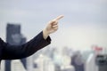 Hand of businessman pointing to the sky with city bokeh lights and skyscraper, heading to the future concept Royalty Free Stock Photo