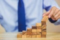 Businessman pulling out or placing wood block on the tower, plan and strategy in business Royalty Free Stock Photo