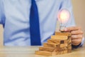 Hand of businessman pulling out or placing wood block on the tower, plan and strategy in business Royalty Free Stock Photo