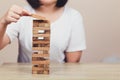 Hand of businessman pulling out or placing wood block on the tower, plan and strategy in business Royalty Free Stock Photo