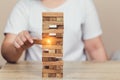 Hand of businessman pulling out or placing wood block on the tower, plan and strategy in business Royalty Free Stock Photo