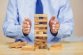 Businessman pulling out or placing wood block on the tower, plan and strategy in business Royalty Free Stock Photo