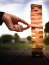 Hand of businessman pulling out or placing wood block on the tower. plan and strategy in business. blur for background Royalty Free Stock Photo