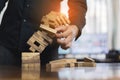 Hand of businessman pulling wood block fail on building