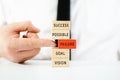 Hand of a businessman pushing red wooden block with word failure out of stack of blocks with positive words