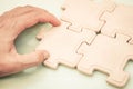 Hand of a businessman putting pieces of jigsaws