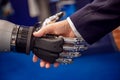 Hand of a businessman shaking hands with a Android robot Royalty Free Stock Photo