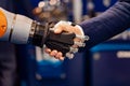 Hand of a businessman shaking hands with a Android robot Royalty Free Stock Photo