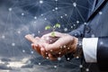 Hand of a businessman shows the sprout of a plant .