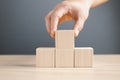 hand of a businessman stacking wood empty four blocks with copy space for text or symbols, development concept for growth success Royalty Free Stock Photo