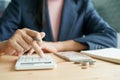 Hand of a businesswoman doing calculating and banknote at the table, Image blurred background of business people, finance, and