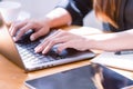 Hand of a businesswoman standing working with a laptop in the office