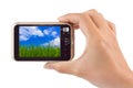 Hand with camera and Grass and cloudy sky my photo