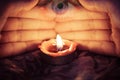 Hand with candlelight burning candle on the darkness background with the eye looking for Astrology Occult Magic illustration -