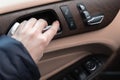 Hand with car door handle inside the luxury car interior with leather and wood design. Close-up view photo Royalty Free Stock Photo