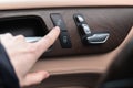 Hand with car door lock switch inside the luxury car interior with leather and wood design. Close-up view photo Royalty Free Stock Photo