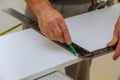 Hand of a carpenter measures the distance using a builder& x27;s square and marks