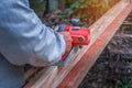 Hand of carpenter using electric planer with wooden plank in carpentry workshop in Thailand Royalty Free Stock Photo